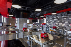 Cozinha equipada para equipe com utensílios e televisões 