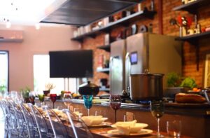 Mesa posta com cozinha e televisão de fundo